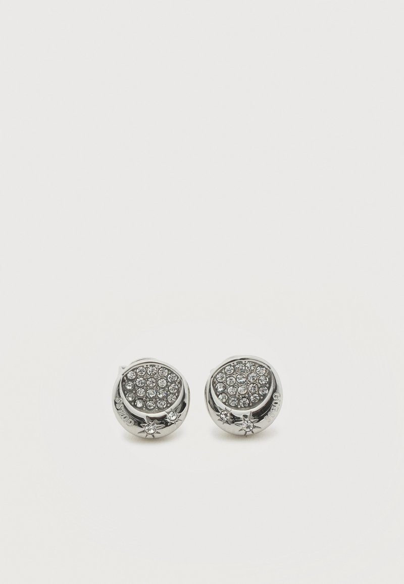 Boucles d'oreilles rondes en argent ornées de cristaux clairs regroupés et de petits accents en forme d'étoile sur un fond blanc uni.