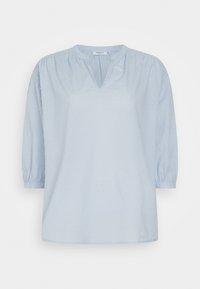 Blusa azul clara com decote em V, mangas bufantes de três quartos e padrão de bolinhas texturizado sutil. Tecido suave, corte relaxado.