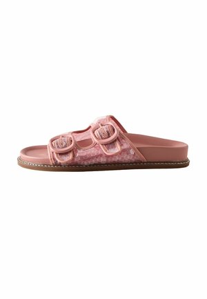 Pink open-toe slide sandal with two adjustable buckled straps and a flat brown sole.