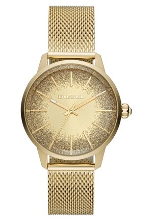 Montre-bracelet Diesel dorée avec bracelet en maille, cadran texturé pailleté, index et aiguilles dorés, et couronne décorative sur le côté droit.