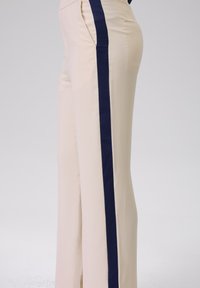 Beige broek met een contrasterende donkerblauwe verticale streep. Gemaakt van soepele stof, met een slim fit en zijzakken.
