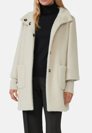 Cappotto in misto lana color avorio con motivo a zigzag, ampie tasche frontali e quattro bottoni sul davanti con un design di colletto ampio.