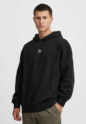 Black hooded sweatshirt made of cotton blend. Features a small logo label on the chest and ribbed cuffs and hem. Relaxed fit.