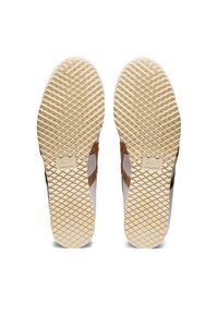 Le suole delle sneaker marroni e bianche presentano una superficie in gomma testurizzata con un motivo a diamante, un logo impresso e pannelli laterali in pelle marrone.