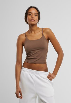 Brown fitted tank top with thin straps, made of smooth material, paired with white loose-fit sweatpants.