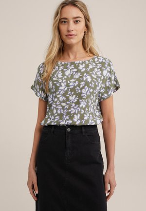 Blouse met bloemmotief in olijfgroen met korte mouwen en een relaxte pasvorm, gecombineerd met een zwart denimrok met hoge taille.