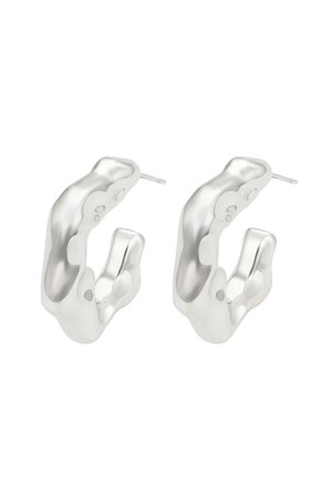 Ezüst karika fülbevalók szobrászati, organikus formával, sima felületekkel és nyitott terekkel, melyek alkalmasak a bepiercelt fülekhez.