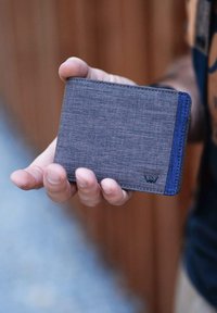 Gray fabric wallet with blue accents, rectangular shape, slim design, featuring visible stitching and a small logo on the front.