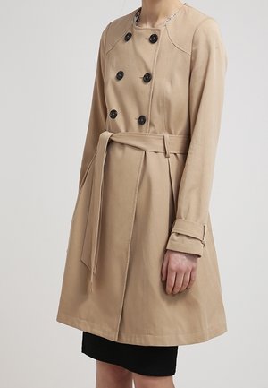 Beige trenchcoat met dubbelgeknoopte knopen, zijzakken en een bijpassende riem. Heeft lange mouwen met manchetten en minimale stikselaccenten.
