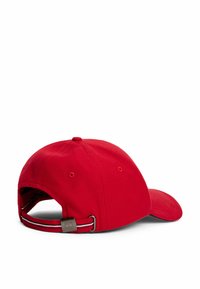 Red cotton baseball cap with a curved visor. Features adjustable strap with metallic hardware and striped accent. Rear view shown.