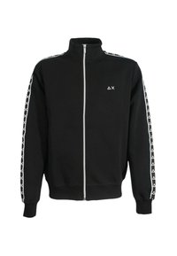 Giacca nera con zip realizzata in un mix di cotone. Presenta un colletto alto e un motivo geometrico bianco lungo le maniche. Logo minimalista sul petto.
