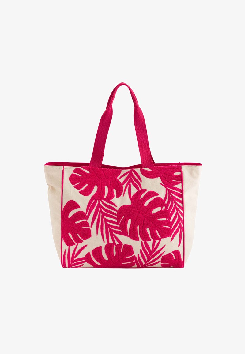 Sac fourre-tout en toile avec une broderie de feuilles tropicales rose vif sur un fond crème. Dispose de poignées roses et d'une forme structurée.
