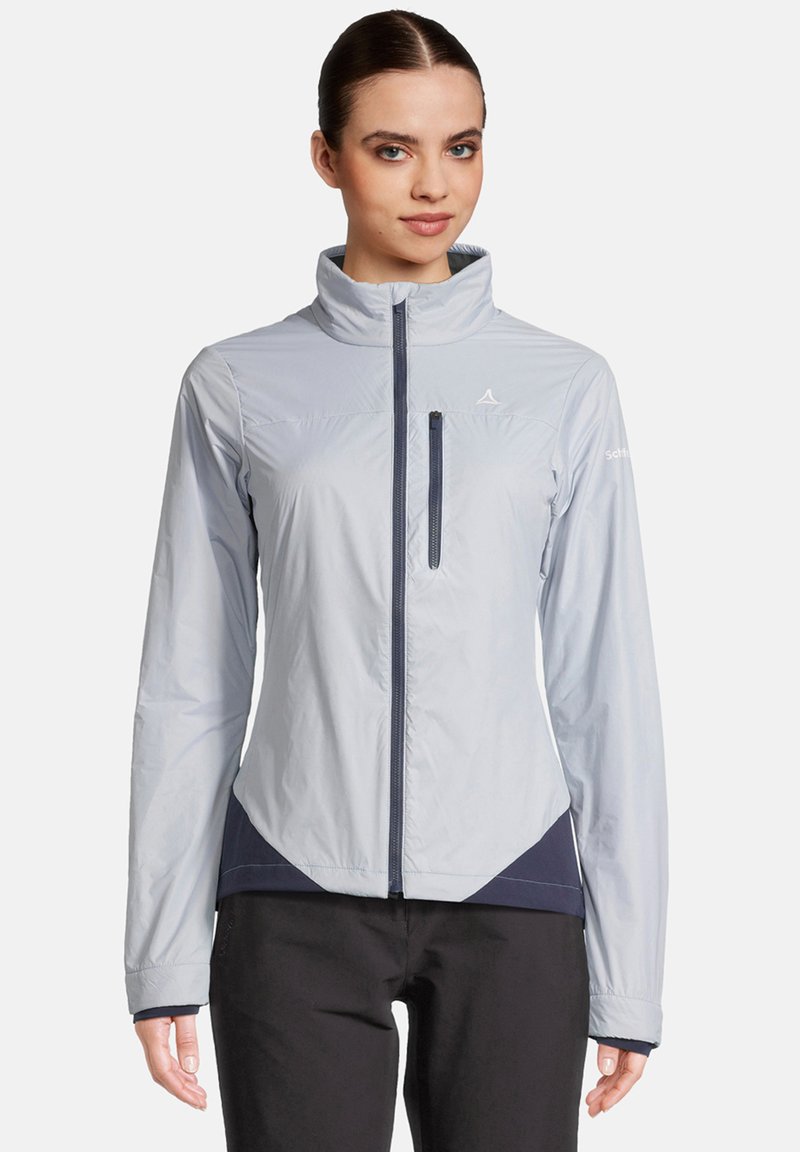 Veste légère bleu clair avec un col haut, fermeture éclair et une poche poitrine ; présente des accents navy et un design ajusté.