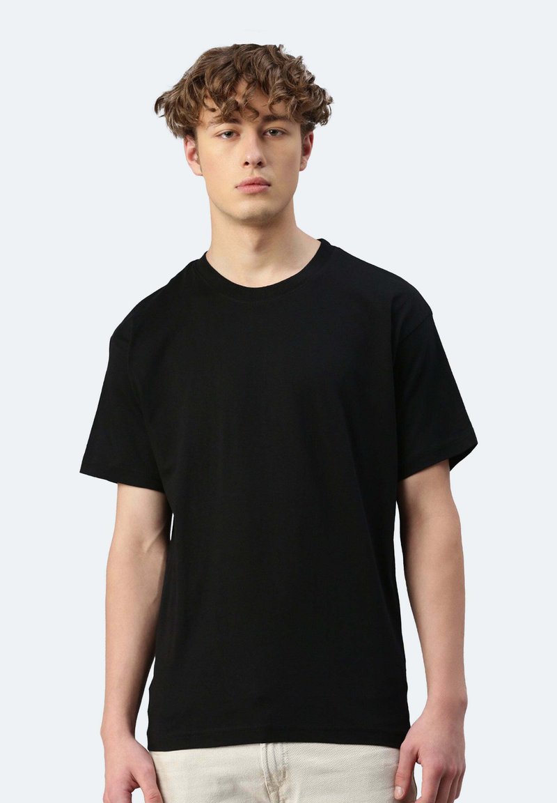 T-shirt nera a maniche corte con scollatura rotonda, realizzata in morbido cotone, caratterizzata da una vestibilità rilassata e senza motivi o dettagli visibili.