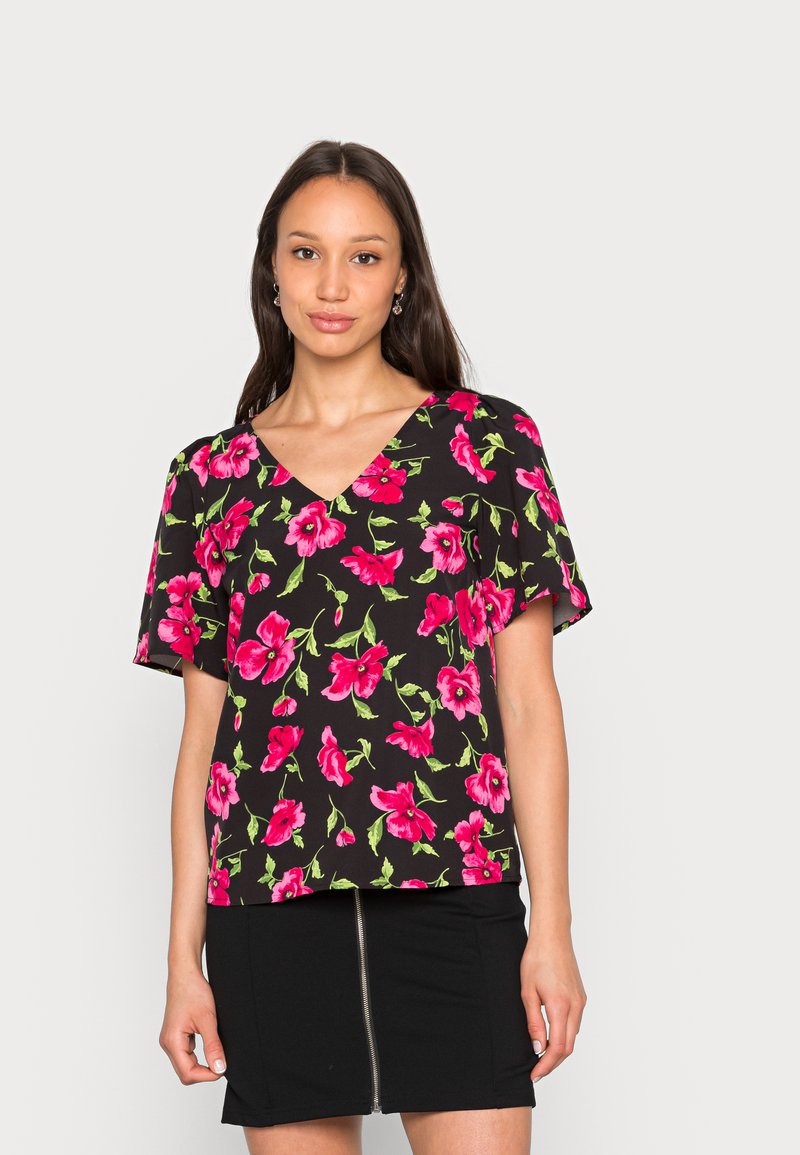 Top preto de mangas curtas com decote em V, apresentando um grande padrão floral em rosa e folhas verdes. Corte solto com textura de tecido suave.