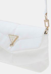 Bolso de mano acolchado blanco hecho de imitación de cuero, con un acento de logo triangular dorado y una correa desmontable.