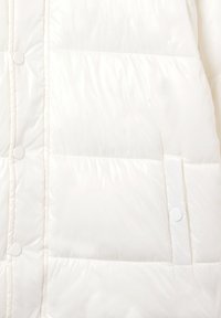 Giacca imbottita bianca con una texture lucida e liscia; presenta chiusure con bottoni, sezioni trapuntate e una tasca laterale con bottone a pressione.