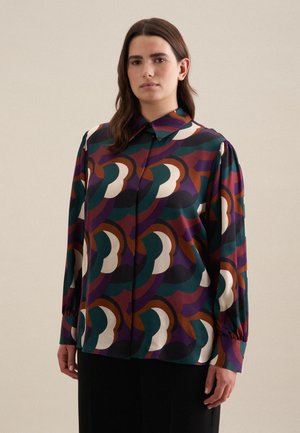 Blusa a maniche lunghe con un motivo astratto multicolore nei toni di verde, viola, marrone e crema. Realizzata in un tessuto morbido e leggero.