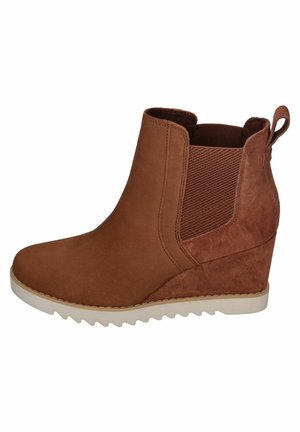 Brown suede ankle boot with wedge sole, elastic side panels, and a pull tab. Textured accents near the ankle. Rubberized outsole for grip.