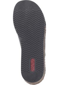 Semelle de chaussure en caoutchouc noir avec un motif de bande de roulement en zigzag. Présente une finition lisse et un logo rouge au centre. Texturée pour une meilleure adhérence et durabilité.