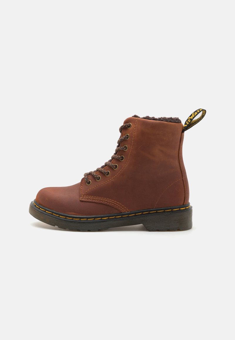 Bottine à lacets en cuir marron avec semelle noire, points jaunes et doublure en polaire, vue latérale sur fond blanc.