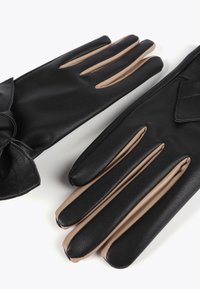 Black leather gloves with beige inner lining, featuring a smooth texture, an accent bow on one glove, and elongated finger openings.