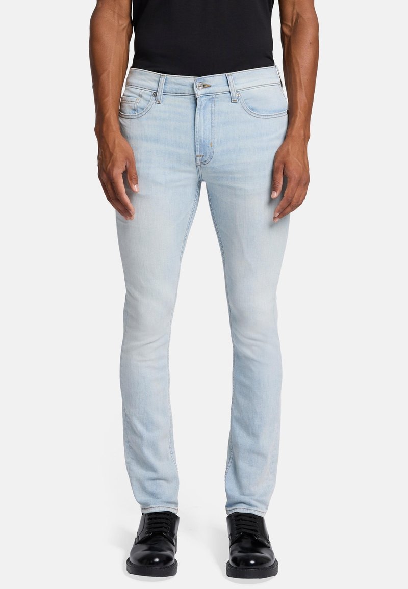 Jasnoniebieskie rurki z lekko przetartym wykończeniem, klasyczny design pięciu kieszeni oraz zamek błyskawiczny. W zestawieniu z czarnymi sznurowanymi butami.