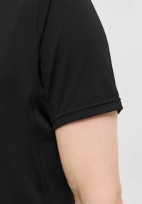 Schwarzes Sportshirt mit kurzen Ärmeln, texturiertem Finish, genähten Nähten und figurbetontem Design.