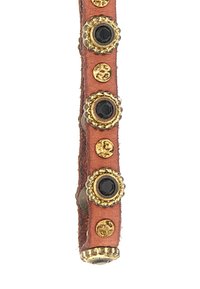 Bracciale in pelle marrone chiaro con borchie circolari dorate e nere. Superficie texture, estremità arrotondate e dettagli decorativi sparsi.