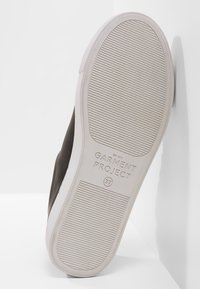 Baskets noires avec une semelle texturée. Dotées d'une semelle extérieure en caoutchouc blanche et d'un logo embossé. Taille indiquée : 37.