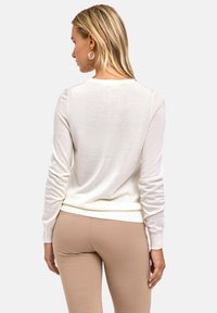 Biały lekki sweter z długimi rękawami, ściągaczami na rękawach i okrągłym dekoltem. Gładka faktura, dopasowany krój oraz subtelne detale przeszyć.