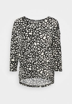 Top a stampa leopardata in bianco e nero, caratterizzato da maniche lunghe, scollatura rotonda e design a orlo asimmetrico. Tessuto morbido.