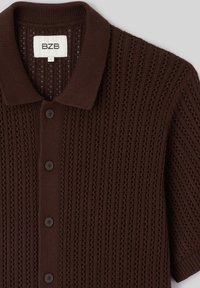 Cardigan marron à manches courtes en maille avec col, fermeture boutonnée devant et motif vertical en maille ajourée, taille large, marque BZB.
