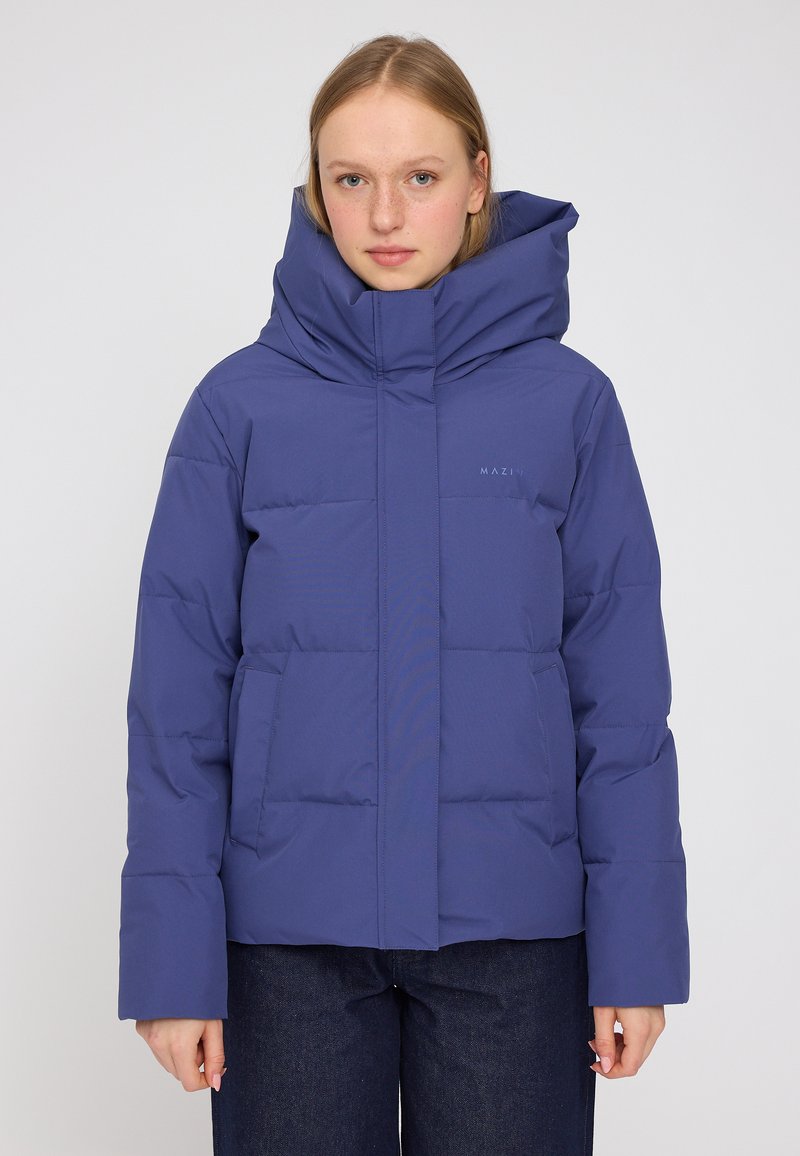 Blauer Puffermantel mit hohem Kragen, großer Kapuze und horizontaler Steppung. Verfügt über Seitentaschen und ein minimalistisches Logo auf der Brust.