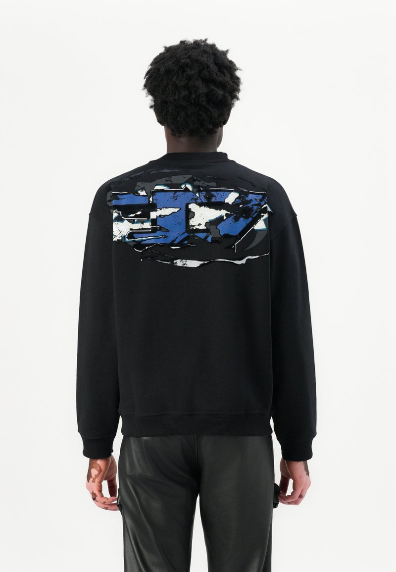 Sweat-shirt noir avec un grand graphique abstrait bleu au dos. Il présente un col et des poignets côtelés, avec une coupe ample.
