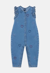 Džinsinis kombinezonas su sagomis priekyje, raukiniais ant rankovių ir daugiadiene širdelių siuvinėjimu. Turi laisvo kirpimo ir tiesaus silueto kelnes.