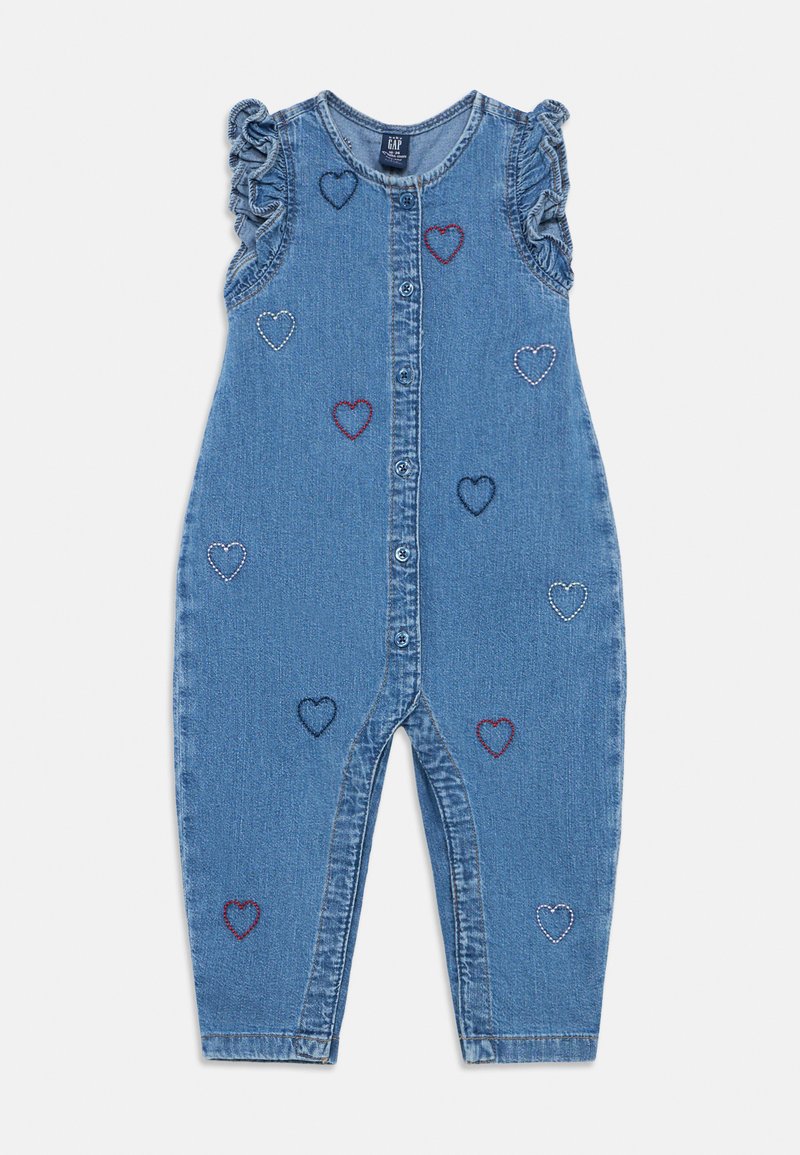 Džinsinis kombinezonas su sagomis priekyje, raukiniais ant rankovių ir daugiadiene širdelių siuvinėjimu. Turi laisvo kirpimo ir tiesaus silueto kelnes.