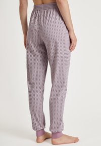 Licht paarse geblokte pyjamabroek met een elastische tailleband en fitted boorden. De stof heeft een zachte textuur en een herhalend geometrisch ontwerp.