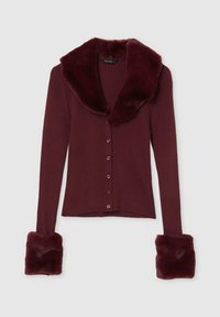 Cardigan a coste bordeaux con colletto e polsini in finto pelliccia, chiusura frontale con bottoni abbinati, design aderente. Texture morbida in tutto il capo.