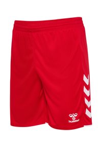 Czerwone krótkie spodenki sportowe z elastyczną talią, białymi paskami w kształcie chevronu po bokach oraz białym logo hummel na przednim brzegu.