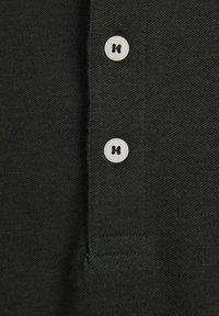 Polo shirt nero in tessuto con trama testurizzata, dotato di due bottoni bianchi in plastica e di un colletto corto. La finitura è pulita, senza decorazioni visibili.