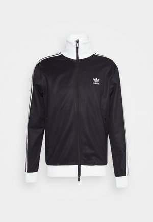 Black track jacket with white accents, full zip, high collar, long sleeves, and Adidas logo on the left chest. Smooth fabric texture.