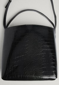 Bolsa tote en negro, de piel sintética tipo cocodrilo con acabado brillante y textura suave, de forma estructurada, que cuenta con dos asas planas para llevar.