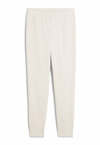 Pantaloni della tuta color beige chiaro realizzati in tessuto morbido. Presentano una vita elastica e gambe affusolate con polsini a costine. Senza tasche né fantasie.