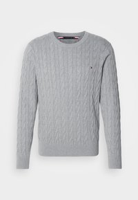 Pull gris clair en maille torsadée avec col rond, manches longues et petit logo Tommy Hilfiger sur le côté gauche de la poitrine.