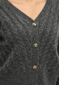 Cardigan grigio a maglia con scollatura a V, caratterizzato da un motivo testurizzato, cinque bottoni di colore chiaro a contrasto e una finitura morbida e pelosa.