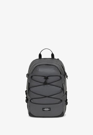 Sac à dos gris en tissu robuste, doté d'un design en cordon élastique sur le devant, d'une poignée supérieure et de bretelles réglables pour le confort et la praticité.