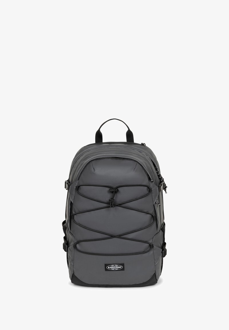 Zaino grigio realizzato in un tessuto robusto, con un design a corda bungee nella parte anteriore, manico superiore e spallacci regolabili per comfort e utilità.