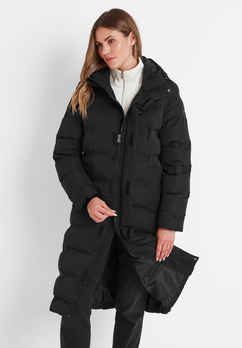 Black puffer coat with a hood, features a zippered front, large baffles for insulation, and adjustable cuffs. Worn over a white inner layer.