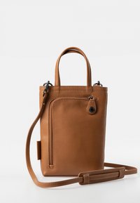 Braune Ledertasche mit kurzen Griffen und einem abnehmbaren Schultergurt. Verfügt über eine vordere Reißverschlusstasche und eine glatte, strukturierte Oberfläche.